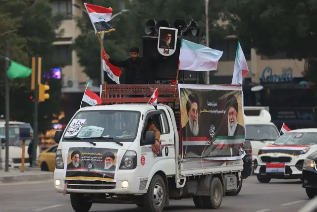 صورة تظهر رجل عراقي يلوح بعلم بلاده خلال تجمع مؤيد لإيران في ساحة التحرير ببغداد، 2 أبريل/ نيسان 2026. 